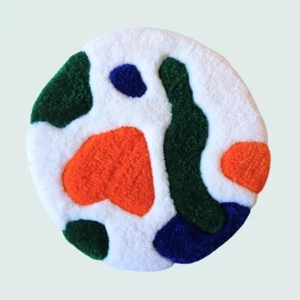 Photo de Galatée, décoration murale tuftée. Laine acrylique dans les tons blanc, orange, vert et bleu.