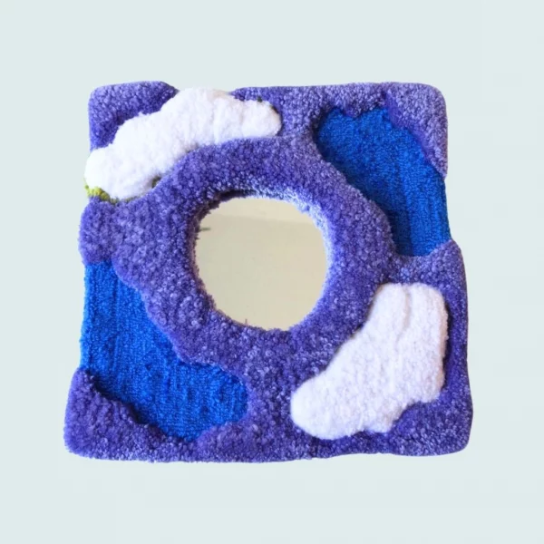 Photo d'Éther, miroir tufté. Laine acrylique dans les tons violet, bleu, et blanc.