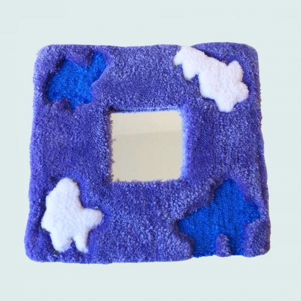 Photo de Zéphir, miroir tufté en gros plan. Laine acrylique dans les tons violet, bleu, et blanc.