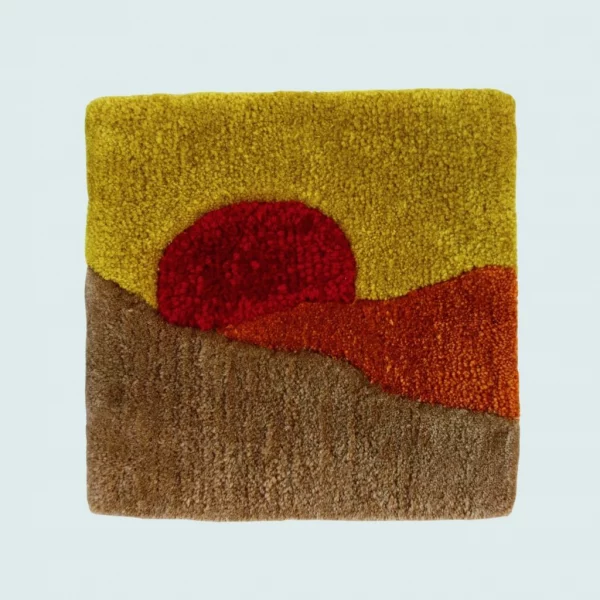 Photo de Crépuscule, décoration murale tuftée. Laine acrylique dans les tons rouge, jaune et marron clair.