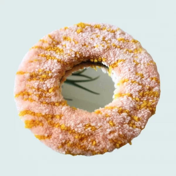 Photo de Pink donut, miroir tufté. Laine acrylique dans les tons roses et jaune.