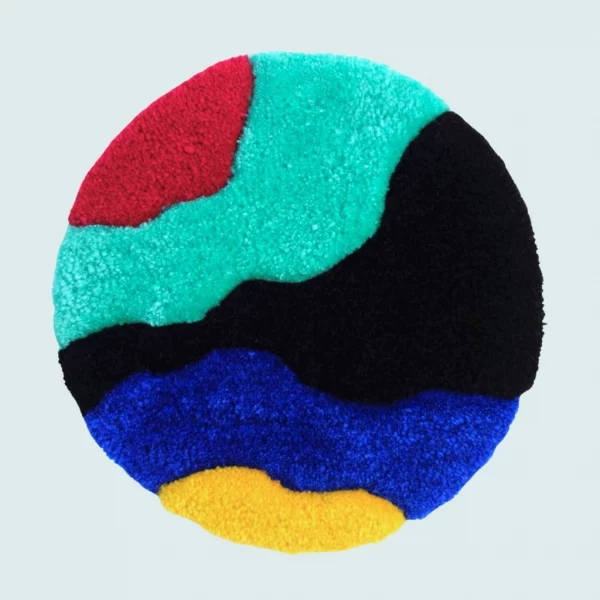 Photo de Mulder, décoration murale tuftée. Laine acrylique dans les tons bleu turquoise, bleu foncé, noir, jaune et rouge.