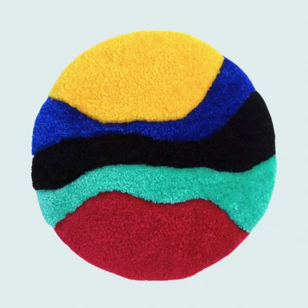 Photo de Scully, décoration murale tuftée. Laine acrylique dans les tons bleu turquoise, bleu foncé, noir, jaune et rouge.