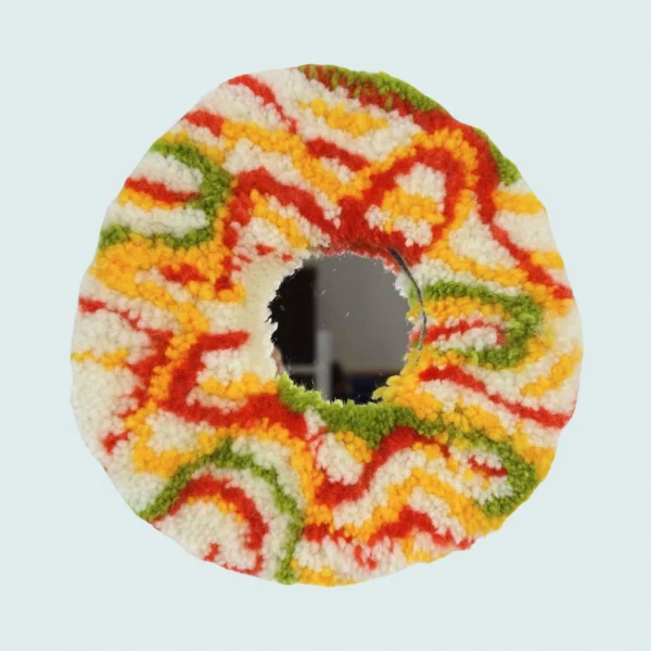 Photo de Psychedelia 2, miroir tufté. Laine acrylique dans les tons crème, vert, rouge et jaune.